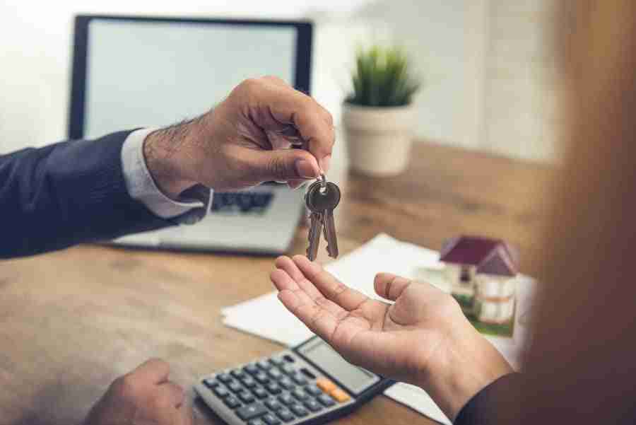 person handing a pair of keys to someone else