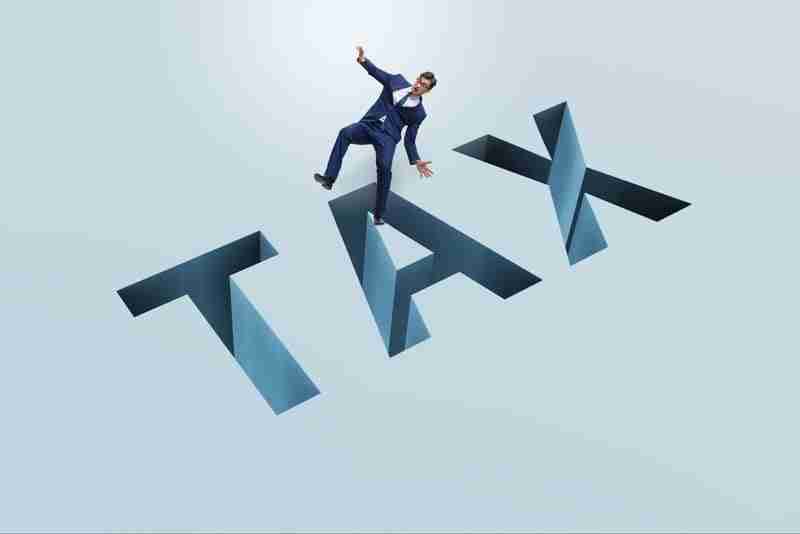 man falling into the word "tax"